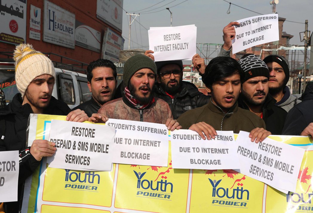 喀什米爾年輕人拿著「恢復網路、簡訊和預付行動服務」標語，在查謨-喀什米爾邦首府斯...