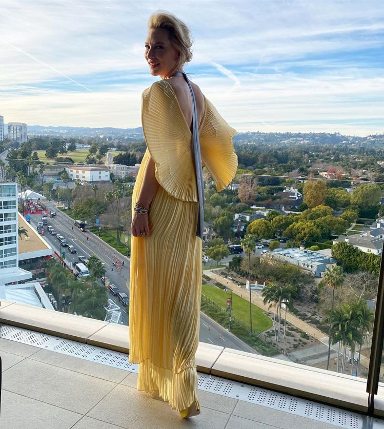 凱特布蘭琪挑選了Mary Katrantzou的淡黃色百摺扇型袖禮服，後空的設計...