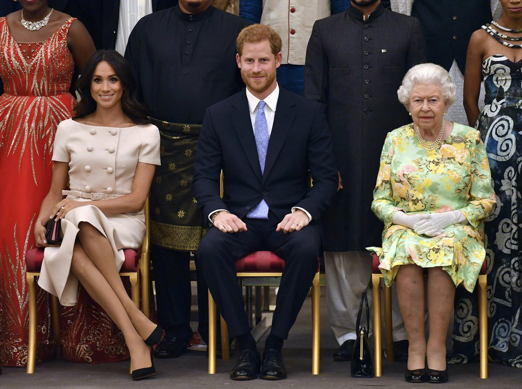 哈利（中）與梅根（左）去年6月和女王伊麗莎白二世一起出席「年輕領袖獎」頒獎典禮。...
