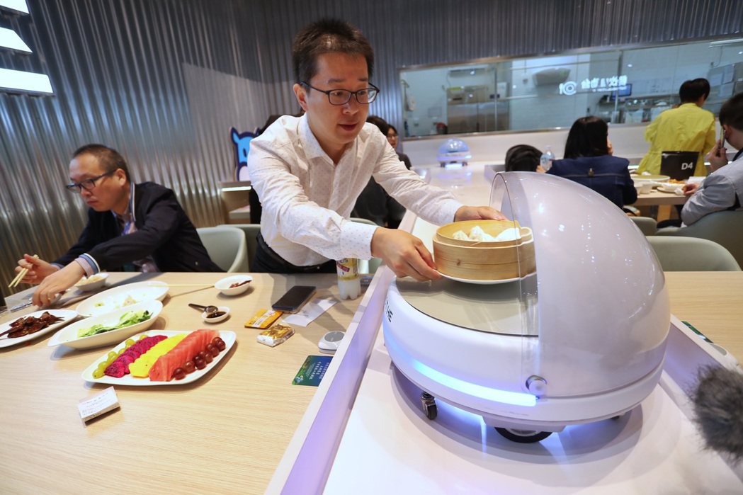 位在上海國家會展中心的盒馬機器人餐廳內，顧客體驗未來感極強的高科技用餐服務。 （...
