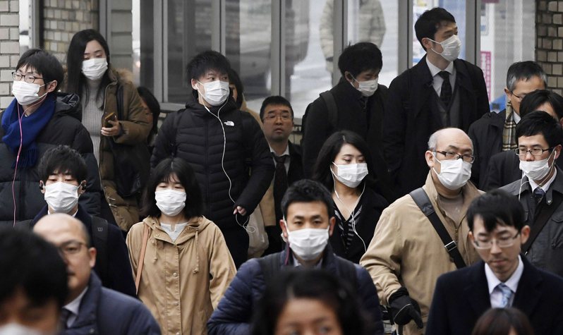 日本奈良街頭許多行人29日戴上口罩。 美聯社