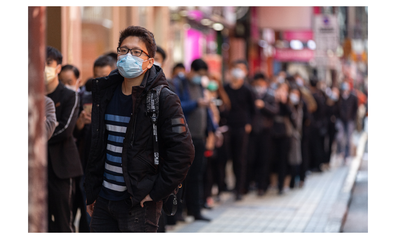 圖為香港一家藥局外，大批民眾正排隊等著買口罩。圖／歐新社
