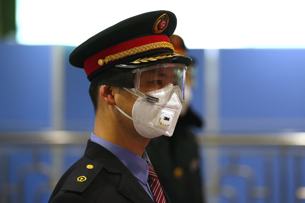 北京西站工作人員佩戴口罩、護目鏡上崗工作。 圖／中新社