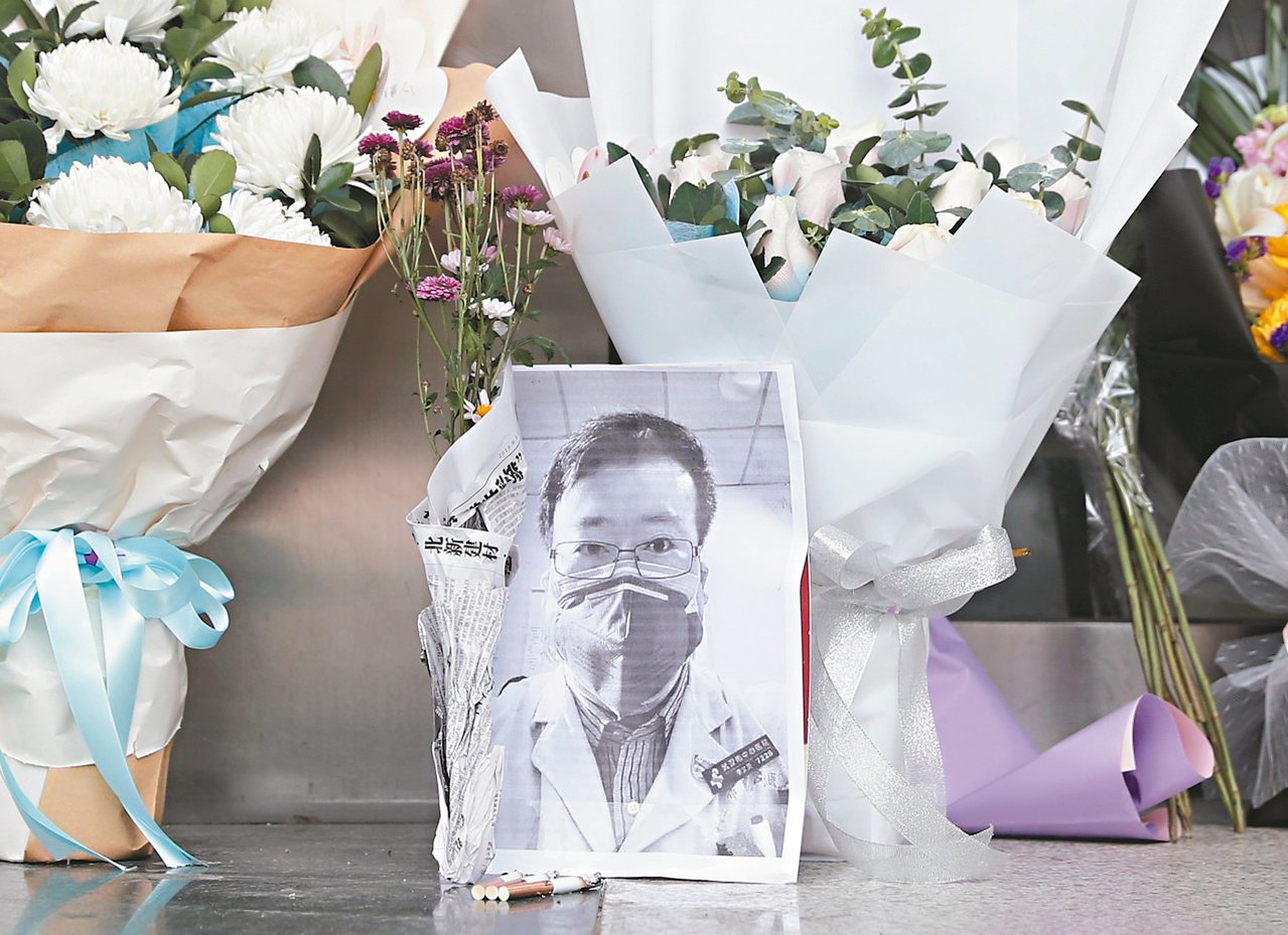 武漢民眾在武漢市中心醫院附近一處臨時處所放置李文亮的遺照悼念他。<br />歐新社