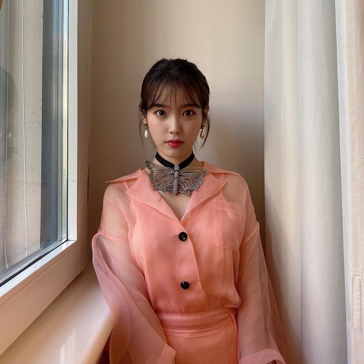 韓國女星IU穿著一襲粉紅色透膚裝翩然現身，粉嫩配色和輕薄材質讓她展現「滿滿仙氣」...