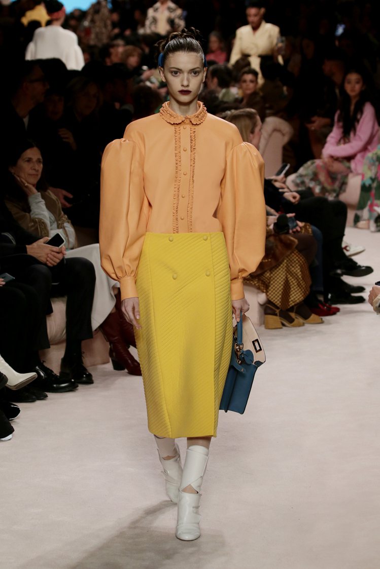 玫瑰橙色皮革光澤質感上衣、杏黃色裙裝，在當代輪廓中展現典雅風韻。圖／FENDI提供