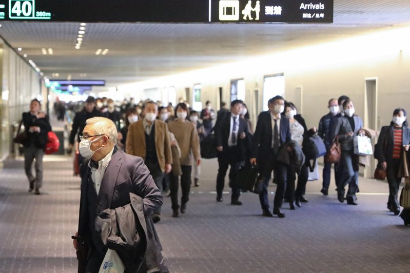 全球疫情升溫，日本確診病例亦不斷提升，民眾戴上口罩自保。圖為日本東京羽田機場。 新華社