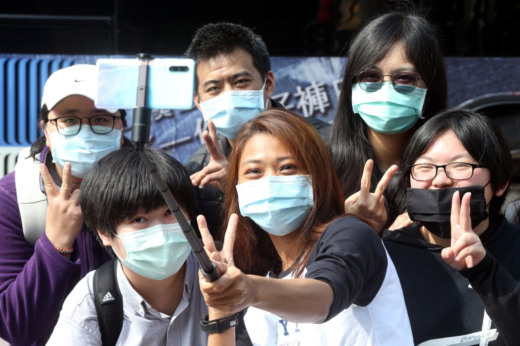 台灣防疫表現相當亮眼。圖為一群年輕人戴著口罩，在西門町拿起自拍棒合照。 圖／聯合...