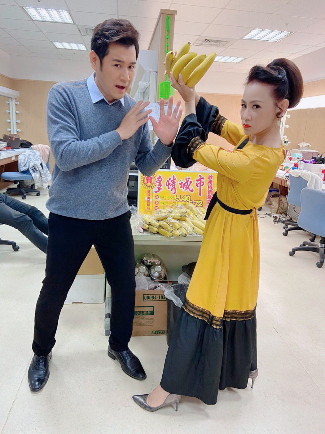 陳熙鋒（左）、兵家綺在「多情城市」戲中的夫妻檔拿著香蕉把玩。圖／民視提供