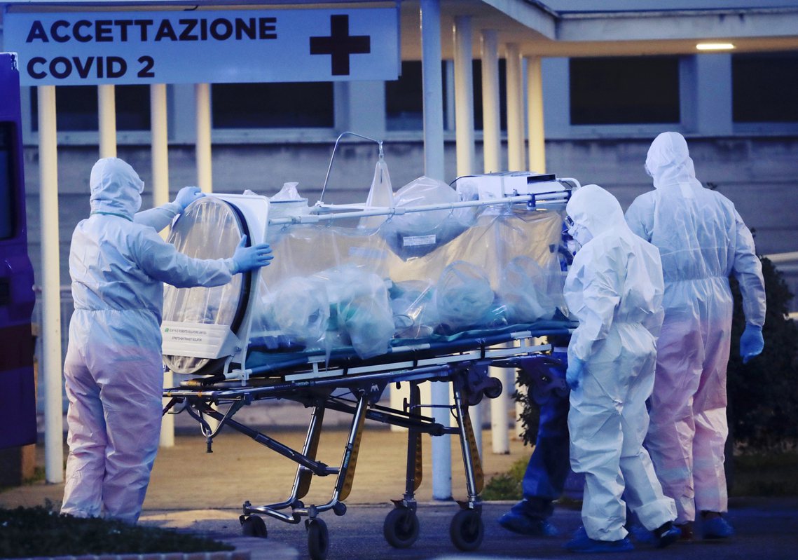 羅馬的醫護人員將隔離病人運至醫院。 圖／美聯社