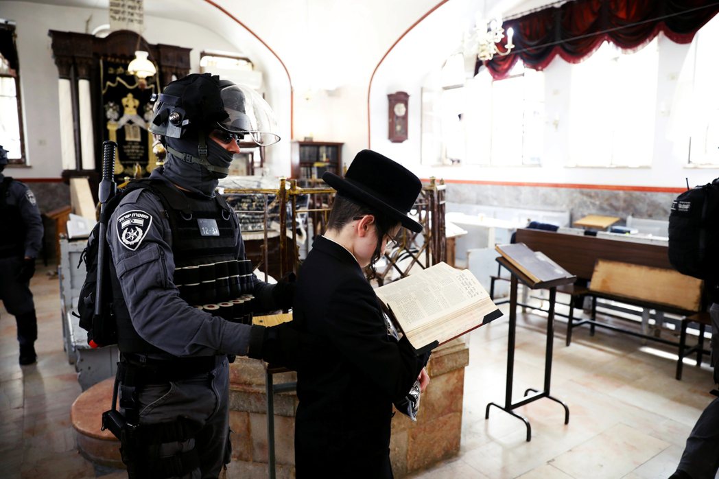 以色列警方關閉百倍之地的猶太教堂前，驅趕裡面的哈雷迪信徒。 圖／路透社