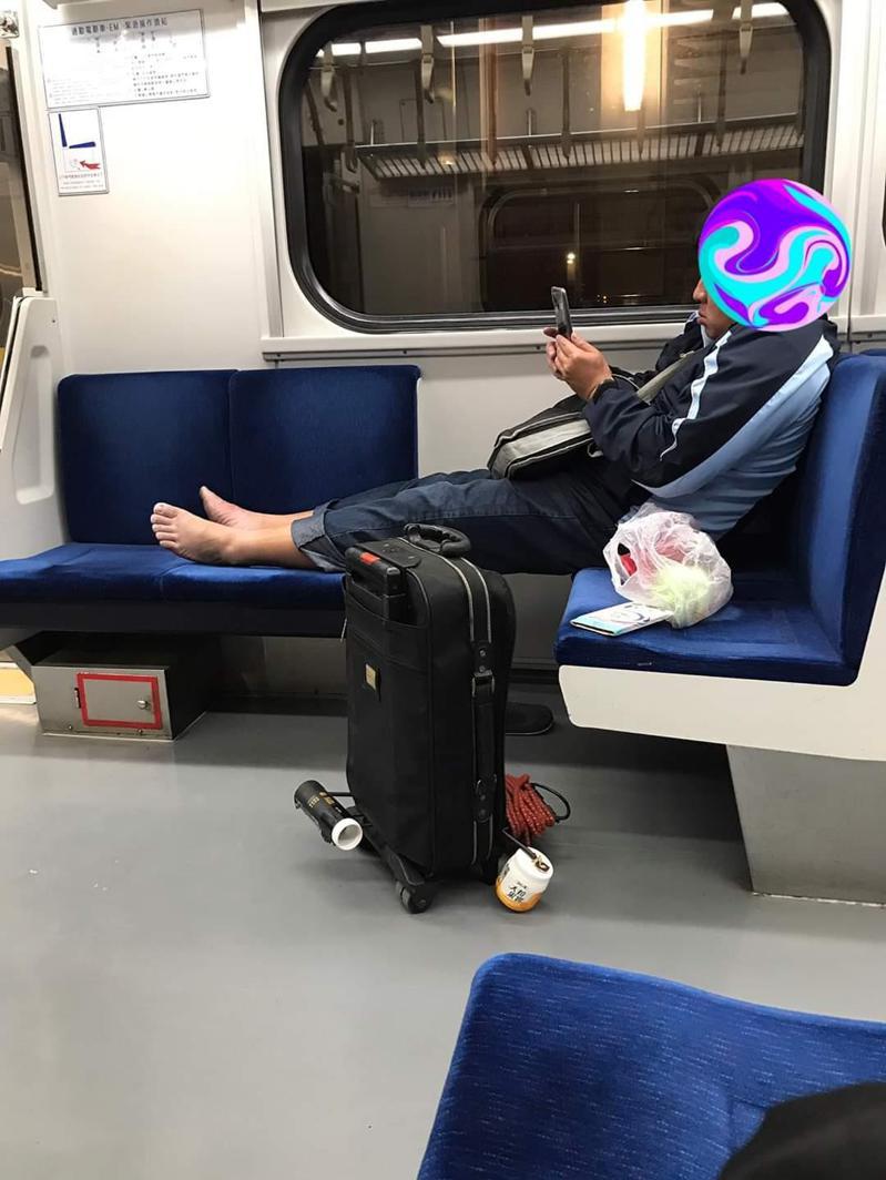 一名男子不僅沒戴口罩，邊滑手機還赤腳跨放在台鐵區間車車廂座位上。圖擷自「爆料公社」