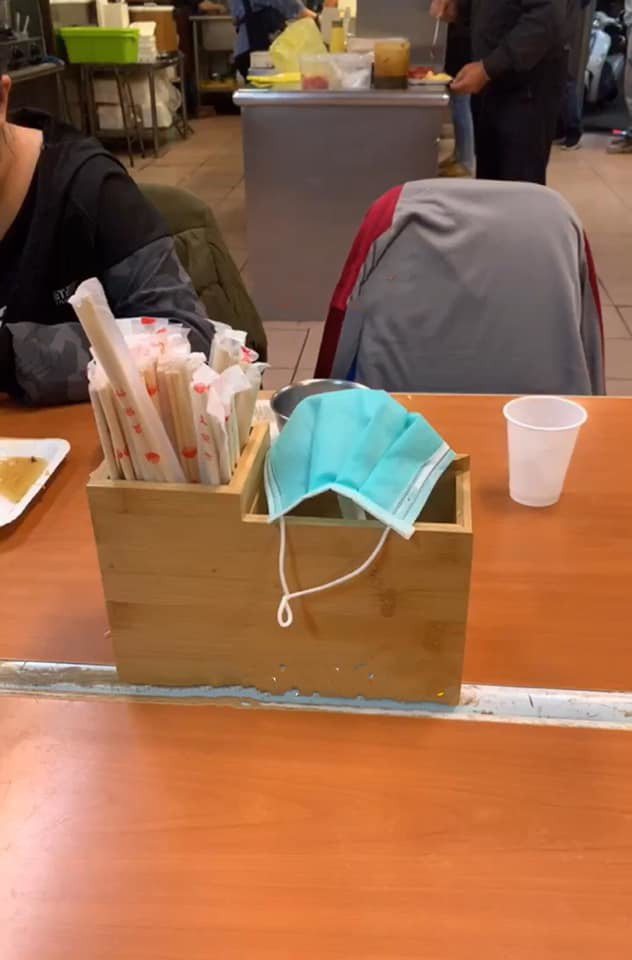 一名網友PO文表示，吃飯時發現有女子將一個用過的口罩掛在餐具盒上。圖／翻攝自爆怨公社