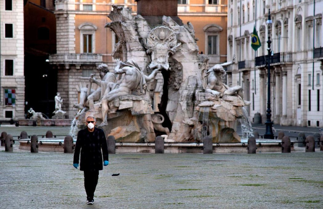 4月17日義大利納沃納廣場一名民眾戴上口罩自保。 圖／法新社