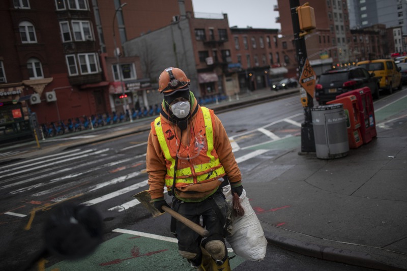紐約市布魯克林區一名戴口罩的建築工人站在路口。美聯社