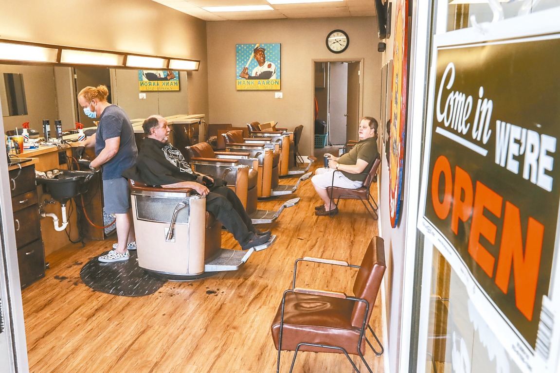 喬治亞州率先解除避疫令，圖為亞特蘭大一家理髮店貼出「我們開放營業」。