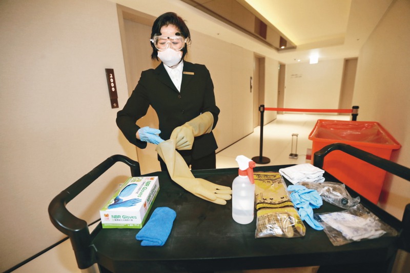 防疫旅館工作人員在服務中隨時更換防護手套，以符合防疫要求。 圖／聯合報系資料照片