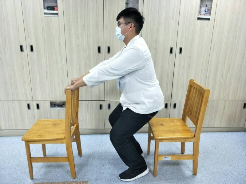扶高背椅半蹲。 圖／童綜合醫院物理治療師陳佑昇提供