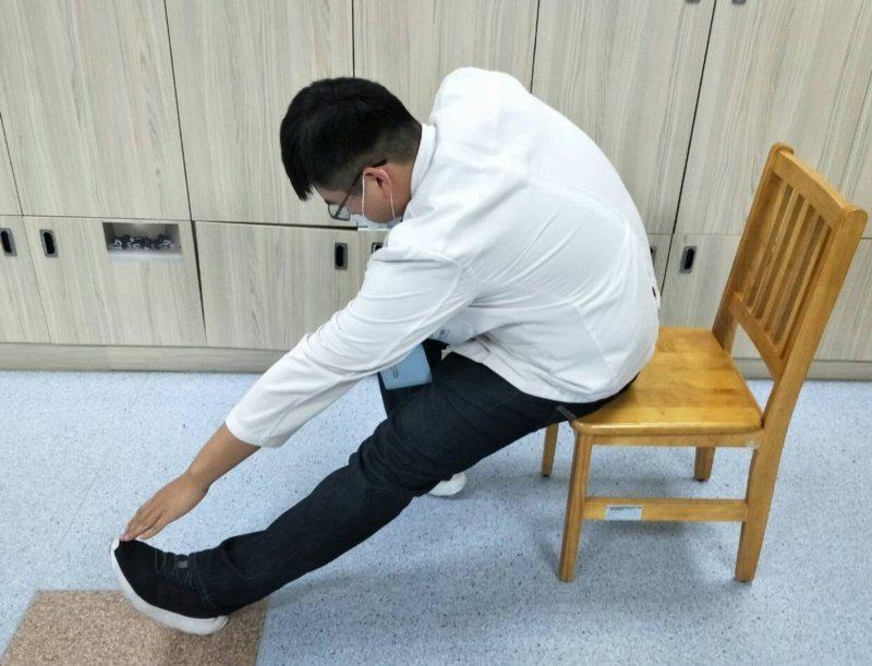 腿伸直手摸腳。 圖／童綜合醫院物理治療師陳佑昇提供