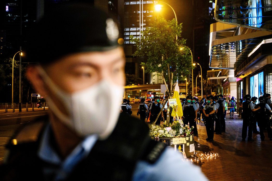 圖為15日，香港示威者「黃色雨衣男」梁凌杰太古廣場跳樓逝世的悼念活動，警察在現場...