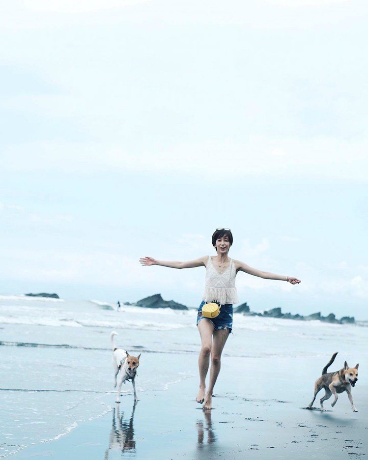 陳庭妮和愛犬在沙灘玩得不亦樂乎，身上的kate spade野餐系列鳳梨造型肩背包成亮點。圖／取自IG