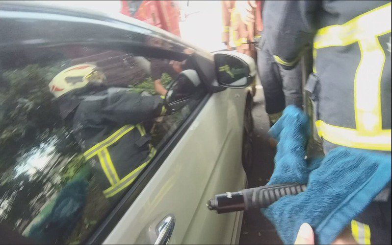 警員余東儒協助消防隊用警棍打破車窗玻璃。記者林昭彰／翻攝
