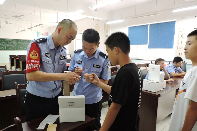 中國四川省什邡市公安正為一名男孩採集血液樣本。圖／取自紐約時報