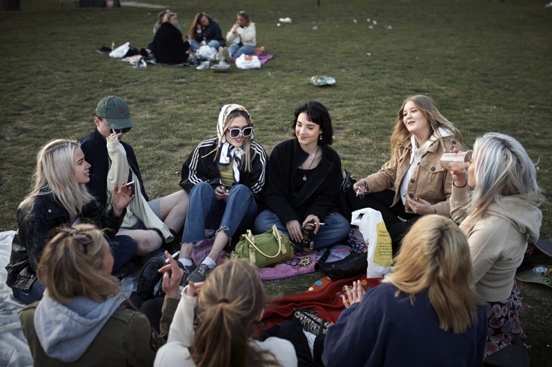 瑞典在今年稍早的新冠疫情期間，不戴口罩、不限制小型集會，也無居家避疫。圖為4月23日的斯德哥爾摩一個公園裡，學生群聚喝酒抽菸。紐約時報
