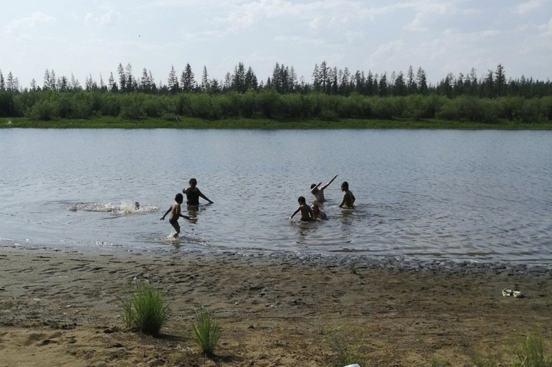 西伯利亞北極圈小鎮維科揚斯克今年氣溫異常溫暖，孩童21日在當地一座湖泊戲水。美聯社
