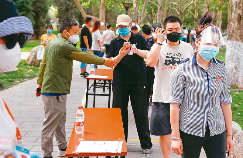 北京人過去一見面，是說「吃了嗎，您吶？」，現在改成「核酸了嗎」。圖為北京民眾在公園排隊接受核酸測試。 路透