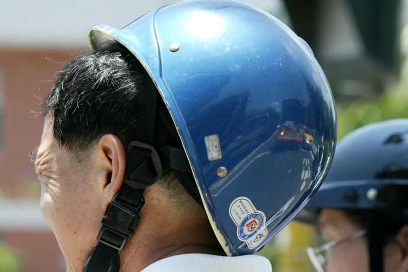 連日酷熱的天氣教人難以忍受，受不了高溫的機車騎士索性將安全帽往後推，讓頭透透氣。 圖／聯合報系資料照片