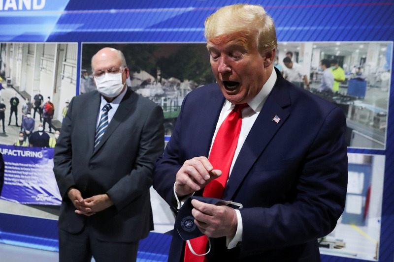 美國總統川普5月21日在視察密西根州伊斯蘭提市的福特汽車公司零件廠時，拿著一個據他說他先前戴過的口罩。路透