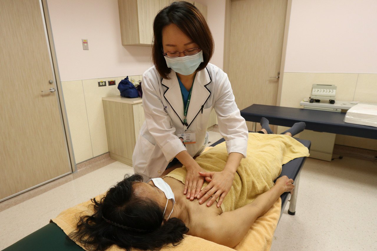 亞洲大學附屬醫院職能治療師張明莉替患者進行徒手淋巴引流。圖／亞洲大學附屬醫院提供