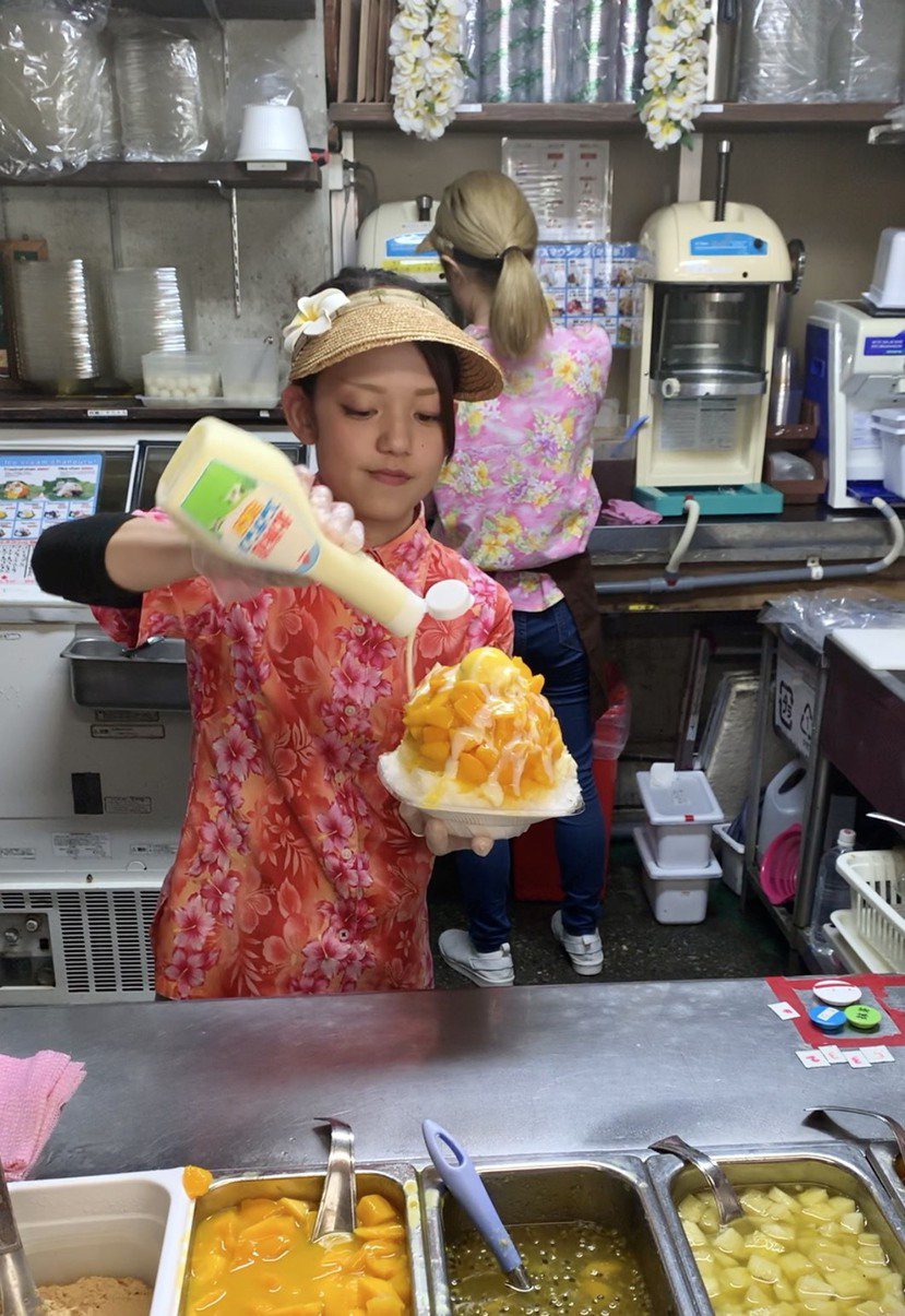 濃濃沖繩風情的花襯衫店員，淋著甜滋滋的煉乳，是恩納之驛休憩市場的美麗風景。 圖／...