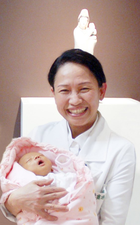 花蓮慈濟醫院試管嬰兒中心主任陳寶珠，開心地抱著嬰兒，認為幫助不孕夫妻生子是她最大...