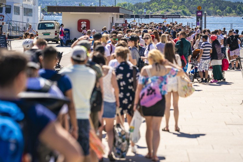 挪威奧斯陸市政廳碼頭大排長龍，民眾準備搭渡輪前往離島遊玩。美聯社