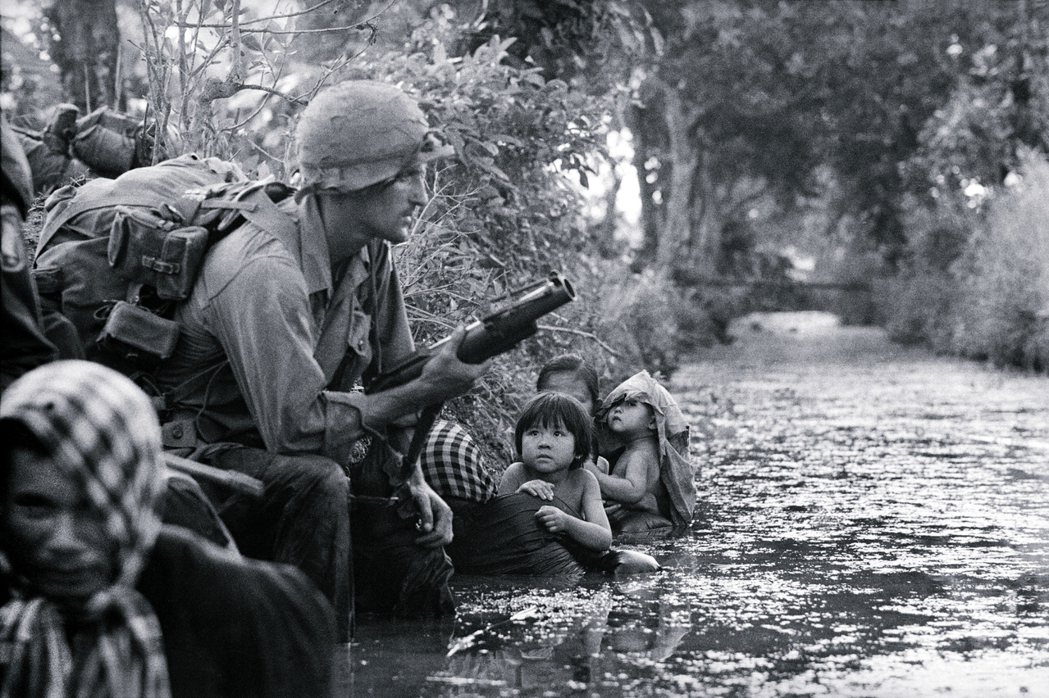 1966年越戰期間，南越的兒童看著美國軍人手持手榴彈。 圖／美聯社