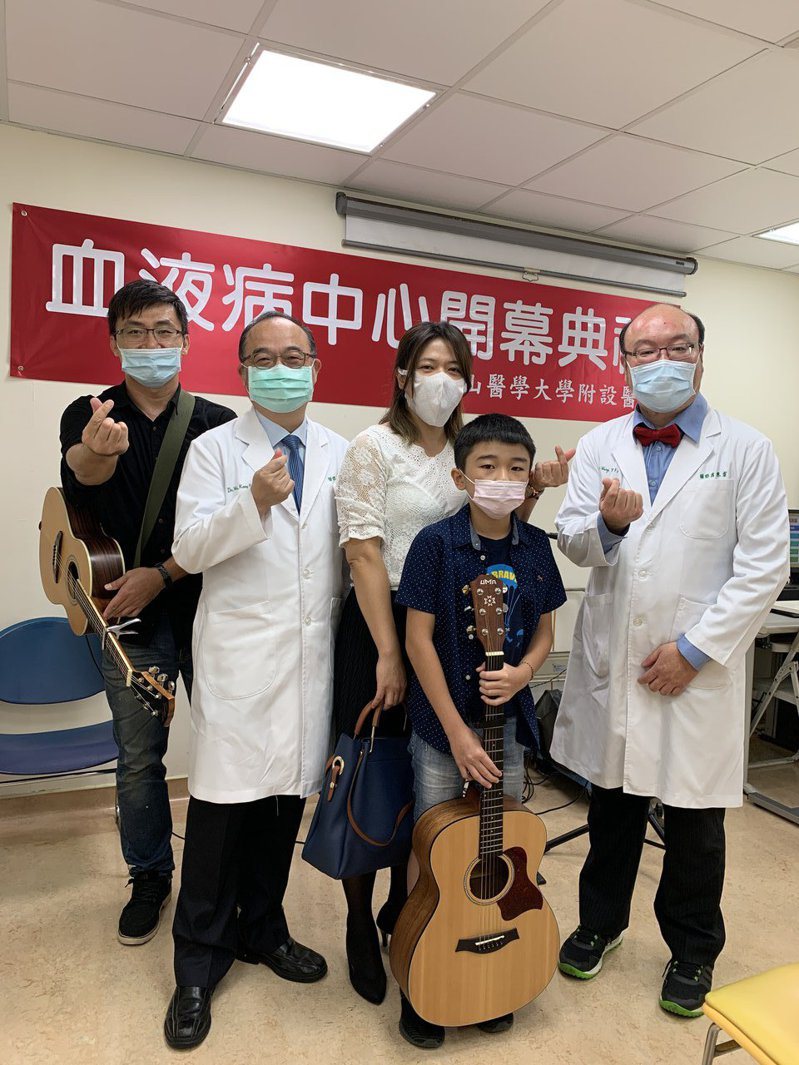 台中市中山醫學大學附設醫院上午成立「血液病中心」，患者李小弟（中）現場演奏吉他祝賀。圖／中山醫學大學附設醫院提供