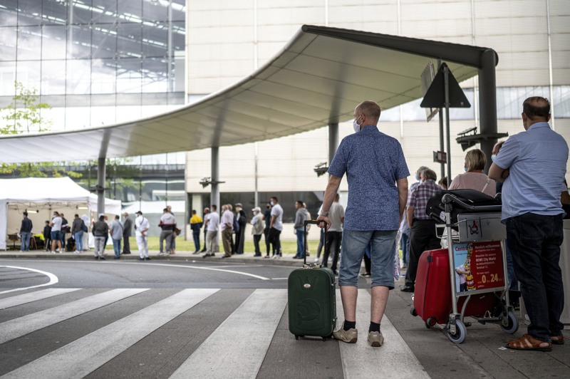 德國8日起針對從高風險區返國的公民及居民，進行強制新冠採檢。圖為德國民眾7月25日在科隆機場的一個新冠檢測站排隊等候檢測。 美聯社