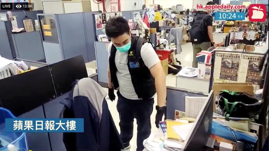 在香港蘋果的同步直播中，可見有港警翻查辦公桌上的資料文件。 圖／經由路透社（香港...