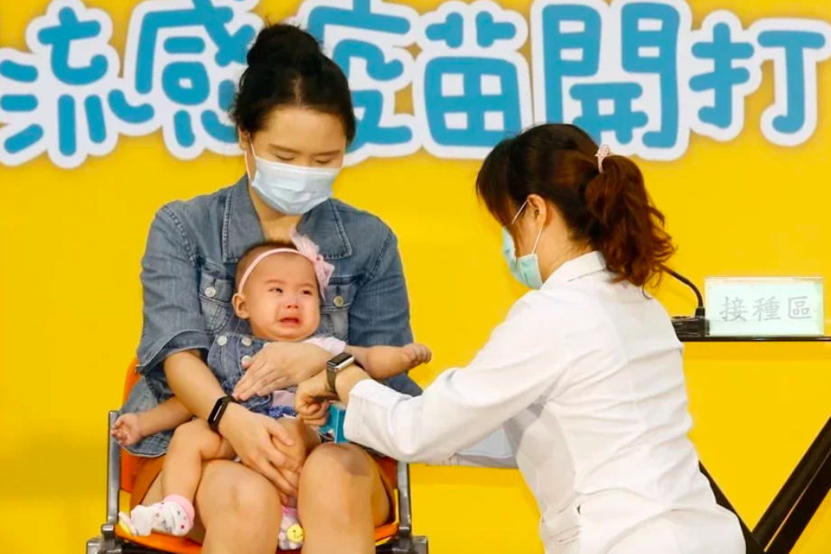衛服部疾病管制署昨上午舉行「守護我們所愛的人」公費流感疫苗開打記者會，邀請一對父母帶著雙胞胎幼兒到現場接種，小女嬰打針後大哭並盯著護士阿姨。記者鄭超文／攝影
