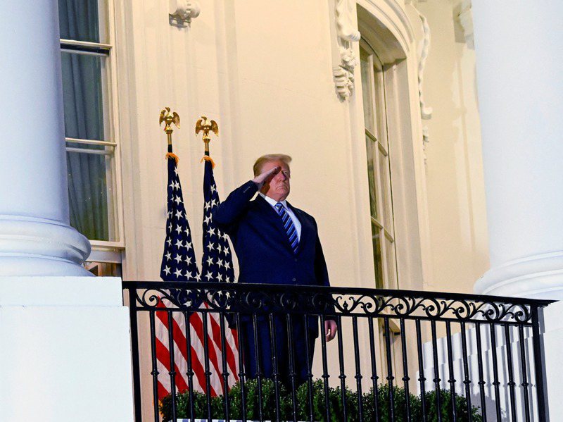 川普乘直升機返回白宮，步下直升機後穿過草坪、走上白宮門前的陽台，隨即脫下口罩，做雙手豎起拇指、行舉手禮等動作。路透