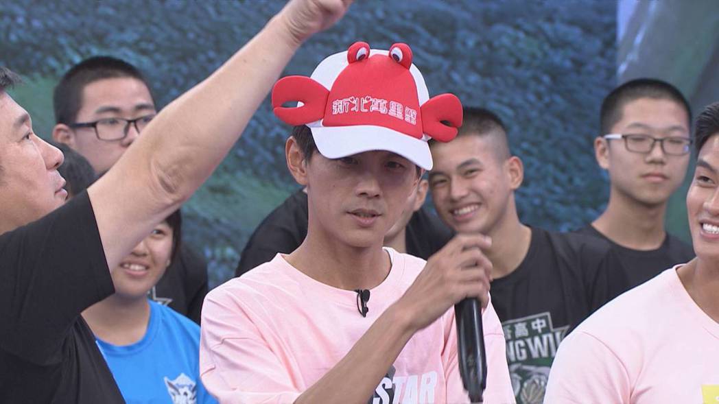 阿翔(右)戴上萬里蟹造型的帽子。圖／民視提供