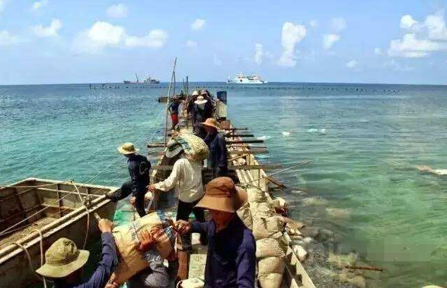 越南多半只能派出簡易的工作船（類漁船），一船一船的把沙石運至礁盤緩慢造島工程。圖／取自今日頭條
