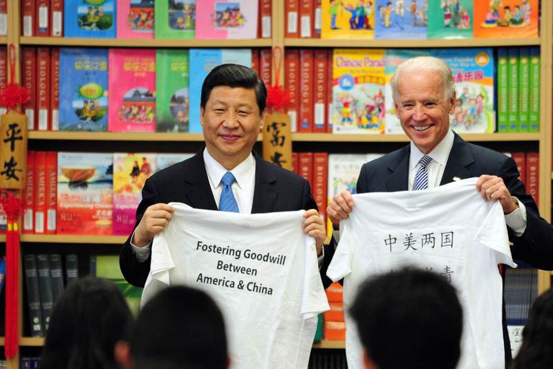 習近平2012年以中國國家副主席身分訪美時，與當時擔任副總統的拜登一同接受洛杉磯附近學生贈送的T恤，T恤上寫著「中美兩國友誼長青」。法新社