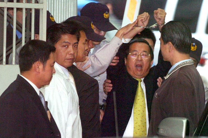 陳水扁高舉戴著手銬的雙手，高喊「政治迫害」、「司法冤獄」、「台灣加油」，隨即由特偵組法警戒護移送台北地院。圖／聯合報系資料照片