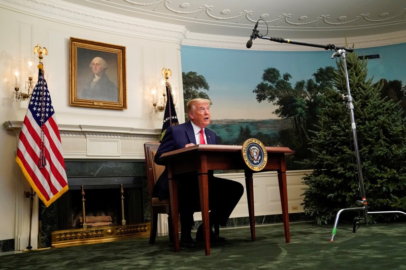 美國總統川普在感恩節當天，坐在一張小桌子後面開記者會。路透