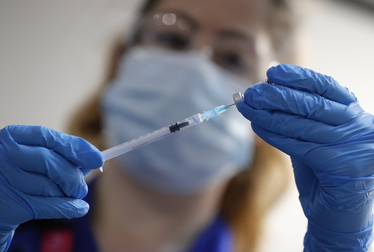 倫敦一名護理師8日準備為民眾施打輝瑞新冠疫苗。（美聯社）