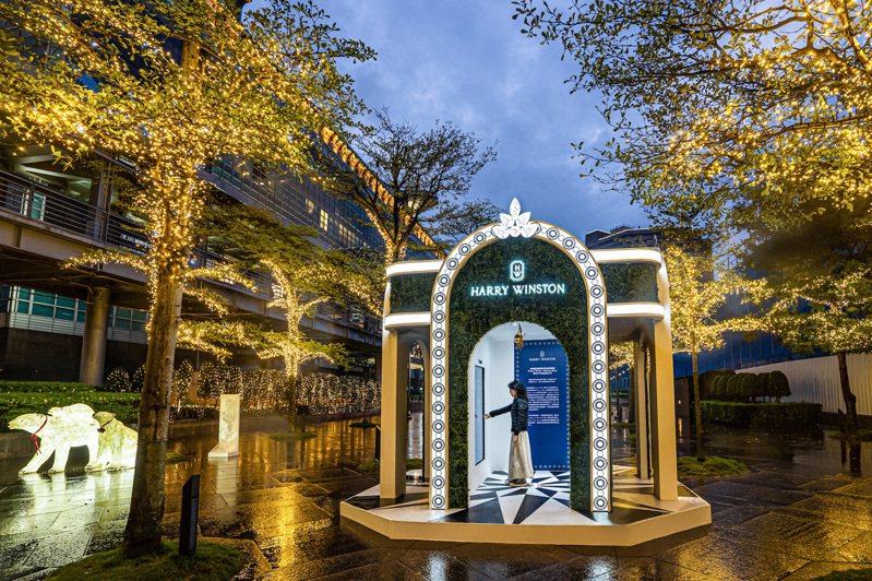 在夜間亮起的海瑞溫斯頓「槲寄花幸福花環之門」將在101旁水舞廣場浪漫屹立至2021年1月15日。圖 / Harry Winston提供。