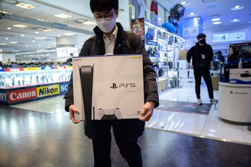 PS5上市後造成全球瘋搶，台灣各線上販售通路將在18日中午12點再度開放預購。圖為首爾一位民眾開心買到PS5。法新社